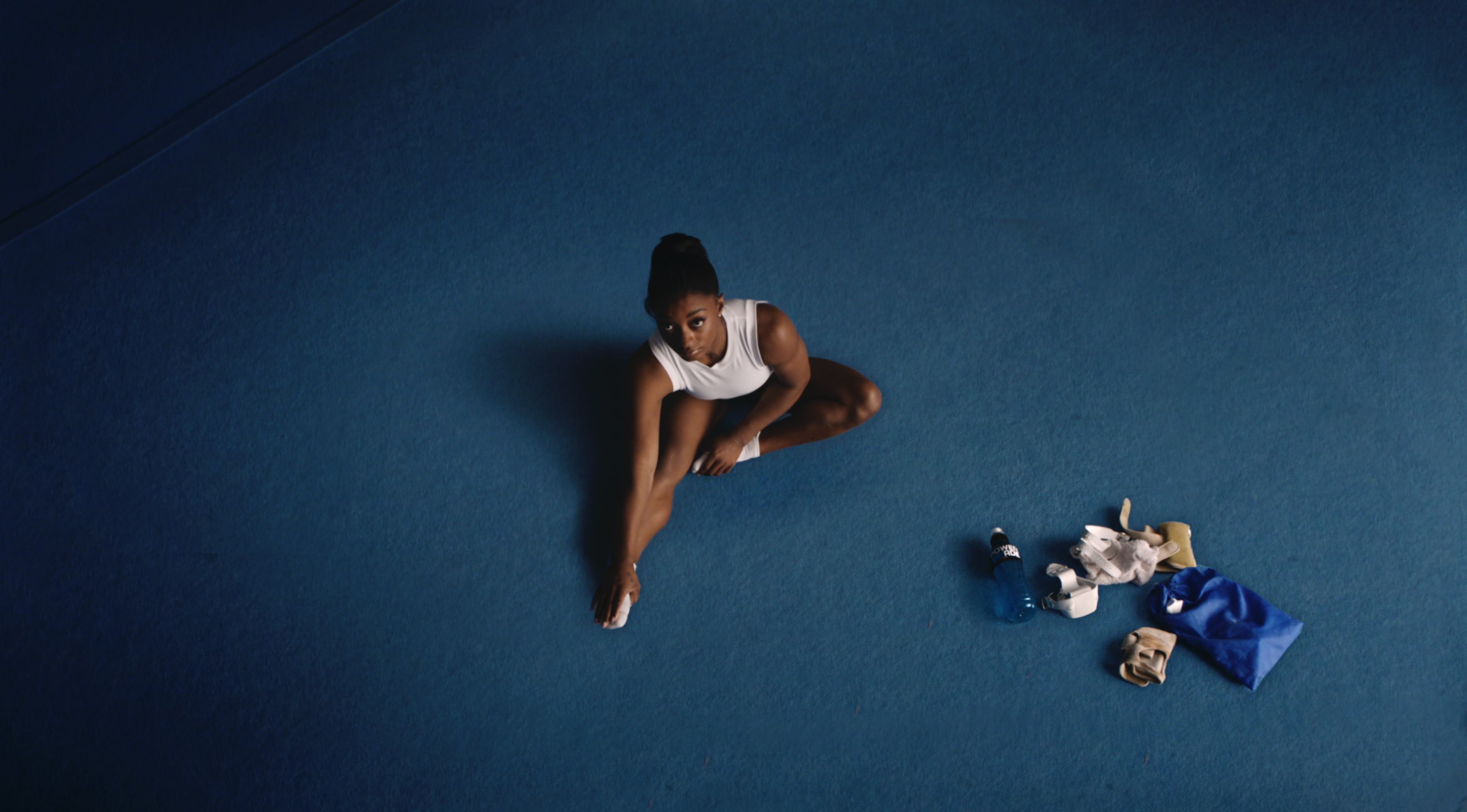Simone Biles sitting on a mat in Powerade's 2024 Olympics ad